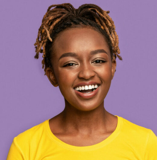 Portrait of young african american woman on purple background with happy smile on face. Lucky person.